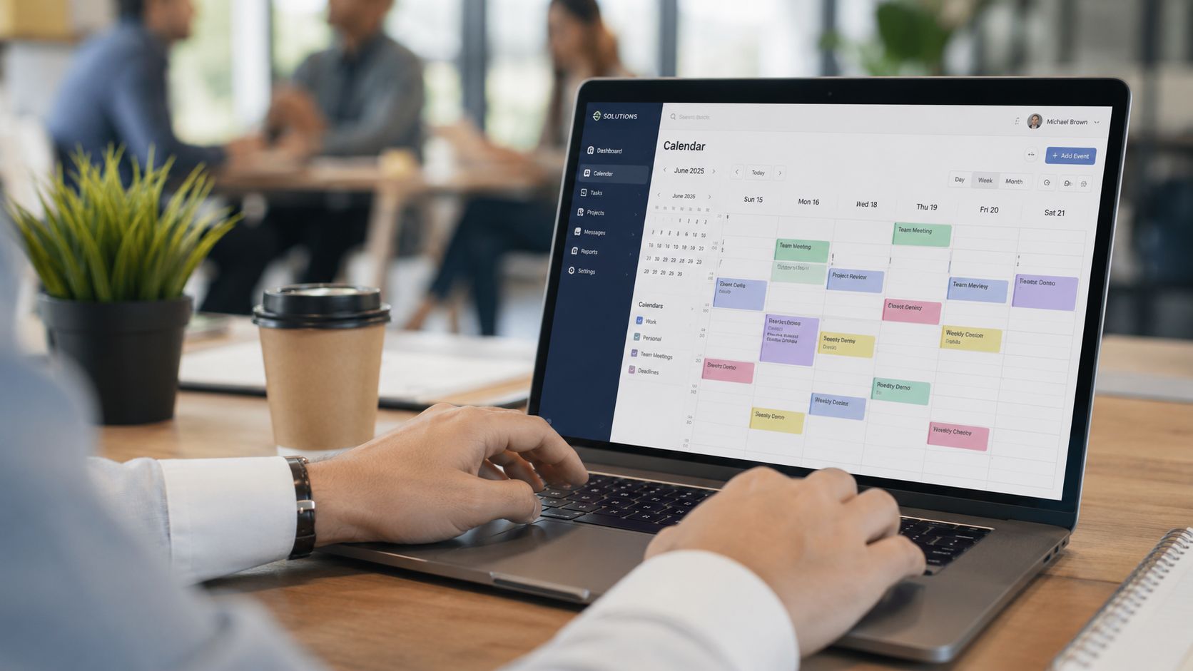 A professional working on a laptop displaying a digital calendar interface in a bright modern office setting.
