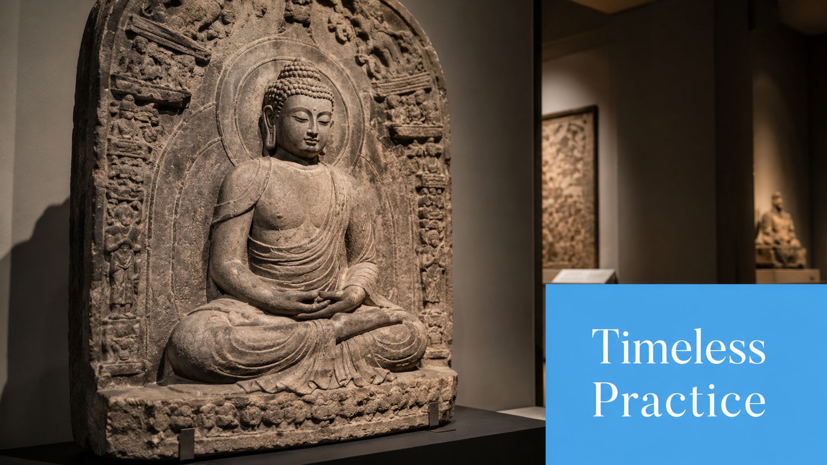 A detailed stone sculpture of Buddha sitting in a meditative lotus pose inside a museum display.
