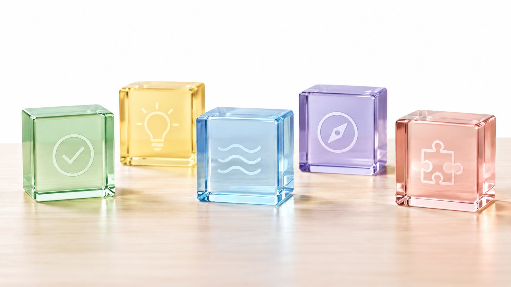 Five translucent glass cubes featuring different icons representing diverse personality traits sitting on a wooden desk.